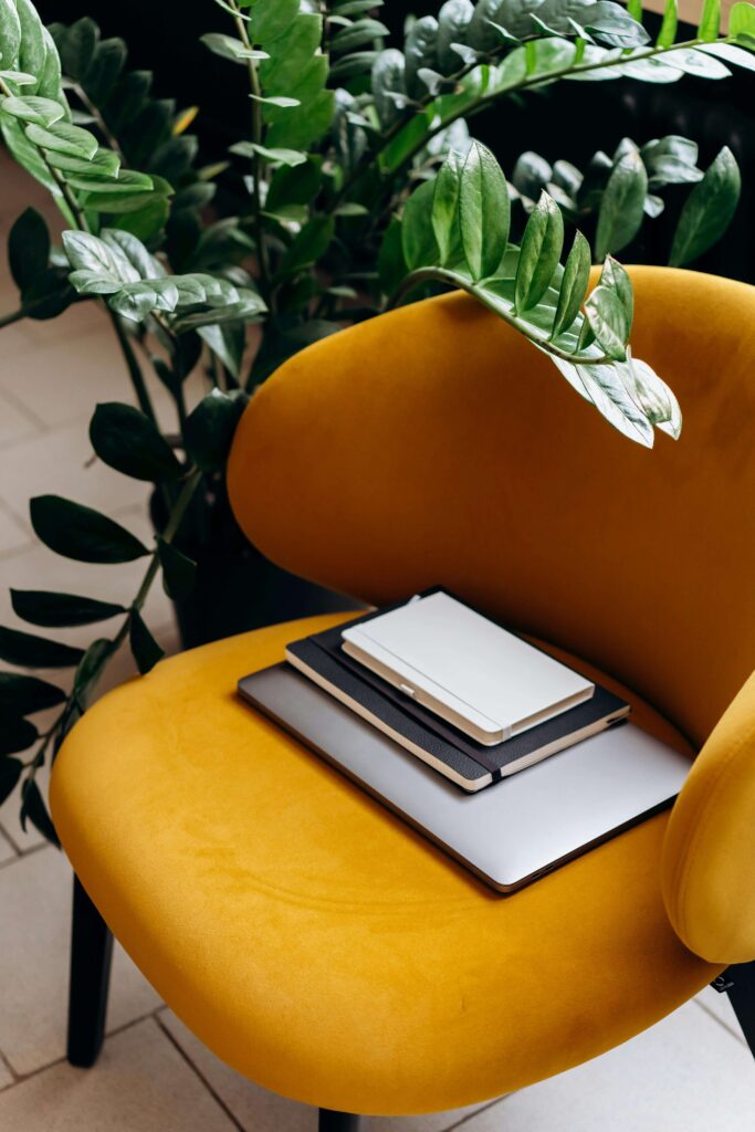 A yellow chair | postpartum therapy in los angeles, ca | online therapy for asian americans | postpartum therapist | Los Angeles, CA 90404 | 90504 | 90505 Photo of a laptop and papers on a stylish yellow chair. Online therapy for Asian Americans in Los Angeles, CA can help you cope with struggles related to postpartum depression and postpartum anxiety. Reach out to a maternal mental health therapist today.