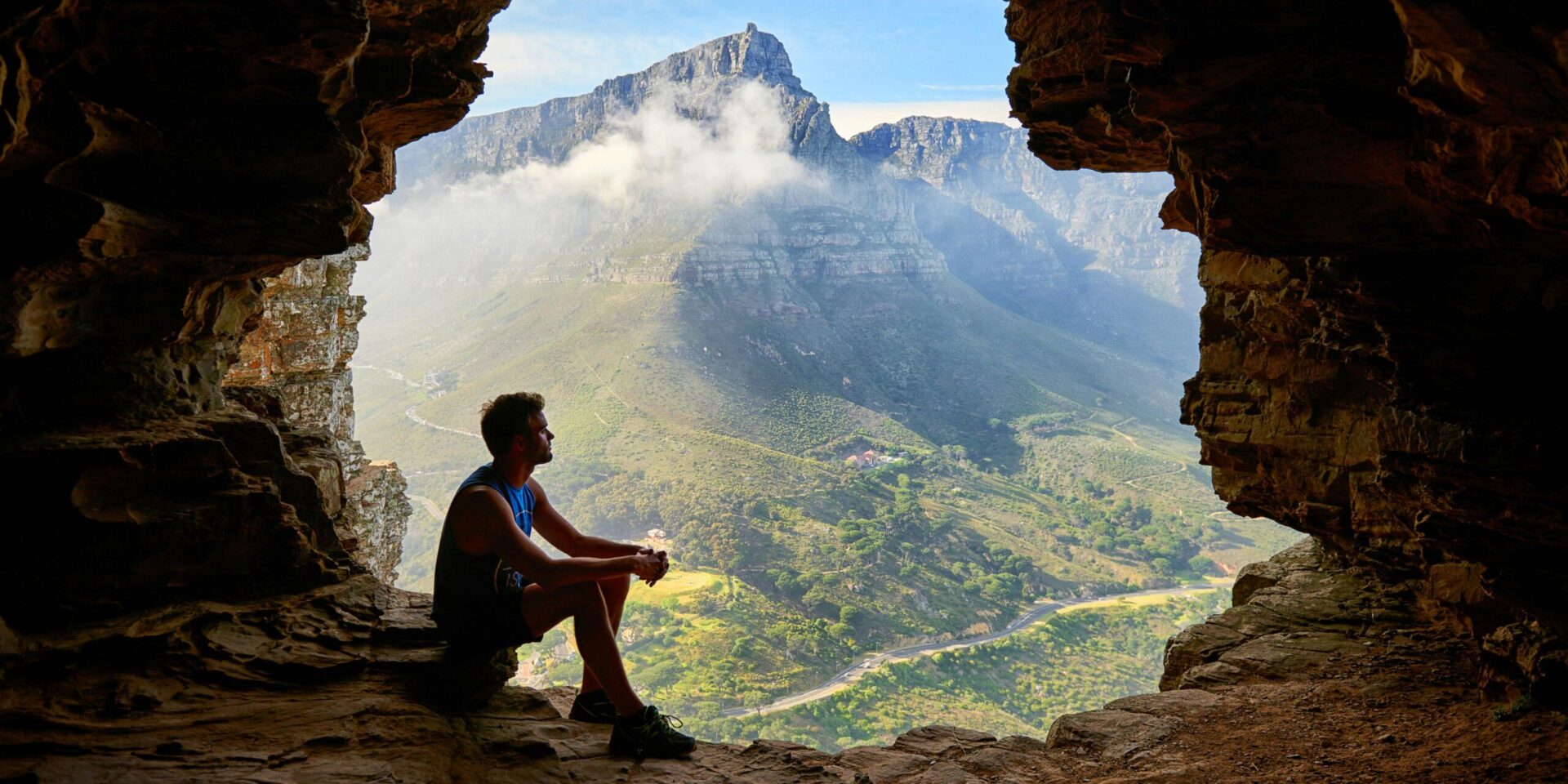 A man sits at the entrance of a cave, gazing out at a breathtaking mountain landscape with misty peaks and lush greenery. Learn more about the support an Asian American therapist in Los Angeles can offer. Contact a burnout therapist in Los Angeles, CA to start burnout treatment and other services.