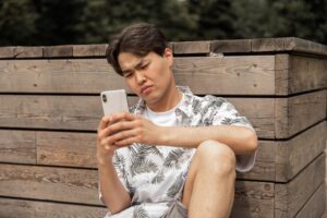millennial man upset looking at phone