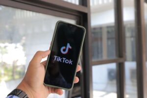 pexels-greenwish-_-137929759-13797847 a hand holding up a phone with the tiktok app open