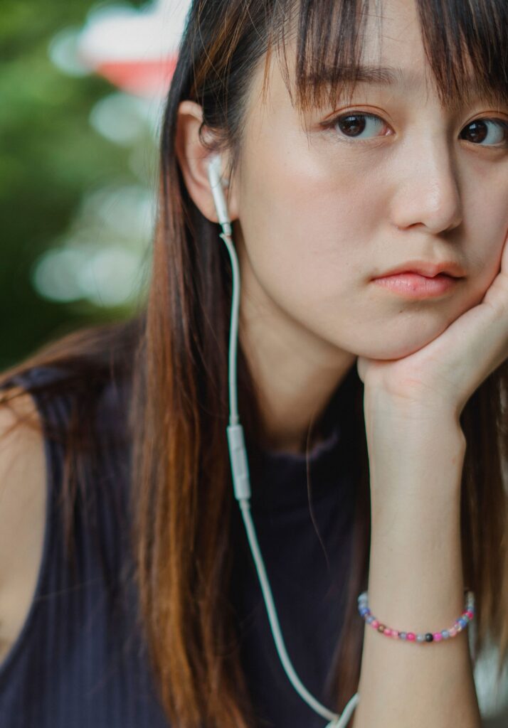 pexels-zen-chung-5538332 An Asian woman looks off to the side pensively, with chin in hand.